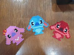 three pieces of perler bead art on a table