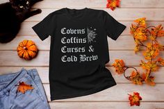 "This \"Cold Brew Coffins and Covens\" goth Halloween Tee is great for witchy fans of all things spooky, cold brew coffee & Covens. Design features a distressed vintage text that reads Cold Brew Coffins and Covens. Great Tee to wear during Halloween season. This witchy tee \"Covens Coffins Curses and Cold Brew\" is perfect for Halloween, Watching Horror Movies and being spooky. Also makes a great gift for Christmas, Xmas, or any Spooky occasion. If you're a witch and a coffee lover than this design is for you! *PROCESSING TIMES, SHIPPING & OTHER INFO* * Our Processing time is 1-2 business days ( Note: Times may vary during the Holiday season) * Please Review Size Chart before ordering. For a more loose fit please order a size up. * Professionally Printed using a DTG (Direct To Garment) Pri Fitted Gothic T-shirt For Fall, Gothic Tops For Fall Costume, Alternative Halloween Cosplay T-shirt, Halloween Cosplay Alternative Style T-shirt, Alternative Style Halloween Cosplay T-shirt, Crew Neck Shirt For Halloween Alternative Fashion, Black Gothic T-shirt For Fall, Black Gothic Shirt For Fall, Gothic Halloween Cosplay T-shirt