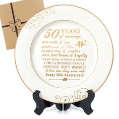 a 50th anniversary plate with a gift box in the background and a card on top