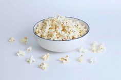 a bowl filled with popcorn sitting on top of a white table