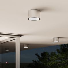 an image of a ceiling light that is on in the dark night time area with trees outside