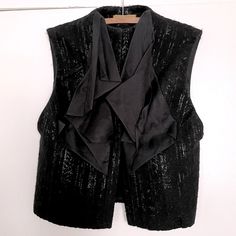 Nicole Miller Black Silk/Wool Vest. Gold Tag. Black Textured Wool. Silk Chiffon Ruffle. Two Magnetic Snaps. No Size Tag, Measures 17” Across By 23” Collar To Hem. Fits M-L. Excellent Used Condition. Black Wool Party Outerwear, Tailored Wool Outerwear For Party, Fitted Black Silk Outerwear, Tailored Silk Outerwear For Party, Wool Outerwear For Fall Party, Fall Party Wool Outerwear, Black Silk Outerwear For Spring, Fall Silk Outerwear For Night Out, Black Silk Outerwear For Fall