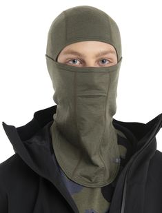 a man wearing a green face mask and black jacket with the hood pulled back over his head