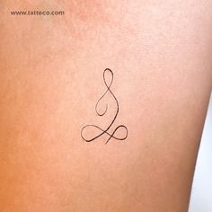 a tattoo on the back of a woman's stomach that has a symbol in it