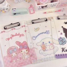 three hello kitty clipboards are sitting on a table next to other stationery items