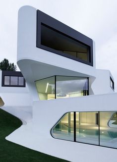 an unusual white house with large windows