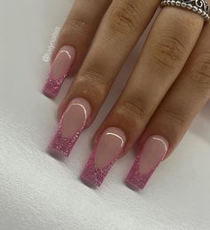 a woman's nails with pink glitter on them