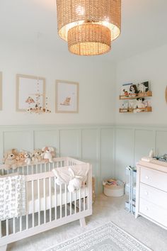 a baby's room with a crib, dressers and pictures on the wall