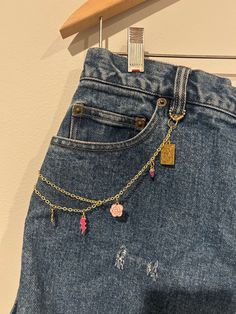 a pair of jeans with charms hanging from them