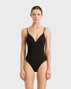 The Emilia One Piece in Black is a classic and elegant swimsuit featuring a triangle bra, adjustable rouleau straps, under-bust support and a medium to high leg line with regular bottom coverage. Emilia is made from our unique Singuleur® fabric that moves with the body like a second skin. Luxury fabric sustainably made in Italy. Garment ethically and sustainably made in Australia. Chic Swimwear With Spaghetti Straps And Lined Body, Classic Summer Swimwear With Lined Body, Elegant Swimwear With Built-in Bra And Triangle Top, Elegant Seamless Swimwear For Sunbathing, Elegant Black Swimwear With Padded Cups, Chic Swimwear With Adjustable Spaghetti Straps, Elegant Triangle Top Swimwear With Straps, Summer Shapewear Swimwear With Removable Bra Pads, Chic Triangle Top Swimwear With Lined Body