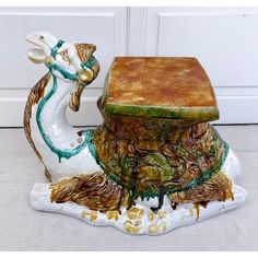 a ceramic figurine sitting on top of a table next to a white door