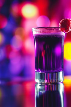 a purple drink with a raspberry on top