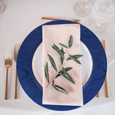 a place setting with an olive branch on the napkin