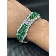 This is part of Chairish’s Fine Jewelry assortment.  This Art Deco Emerald Diamond Wedding Bracelet in 18K gold showcases 40 endlessly sparkling natural emerald, weighing 23.74 carat and diamonds weighing 7.09 carat. It measures 7.5 inches long in length.  Emerald enhances the intellectual capacity of the person. Designed with perfect oval cut emerald set horizontally in between the diamonds with diamond charm in center to make you stand out on any occasion or event. The elegant style complements the attire beautifully and this is a perfect Unique Gift, Bridal Shower Gift, Secret Santa Gift, Gift For Sister, Mother Daughter Gift, Bride To Be Gift, Bridesmaid Gift, Thanksgiving Gift, Anniversary Present, Christmas Gift or any Holiday Gift for Mother, Sister, Daughter, Grandma, Fiancé, Girlf Formal Emerald Diamond Bracelet With Brilliant Cut, Green Diamond Bracelet For Formal Occasions, Luxury Green Brilliant Cut Diamond Bracelet, Formal Emerald Diamond Bracelet, Luxury Green Tennis Bracelet For Formal Events, Luxury Green Diamond Bracelet Hand Set, Luxury Round Emerald Bracelets, Green Diamond Bracelet With Brilliant Cut, Luxury Emerald Cut Green Diamond Bracelet