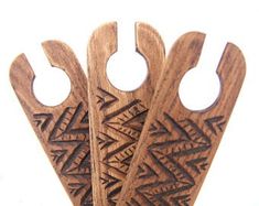 three wooden spoons with designs on them sitting next to each other in front of a white background