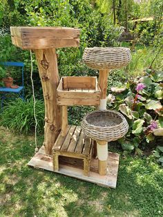 a wooden stand with baskets on it in the grass next to some flowers and plants