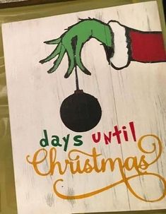 a wooden sign with the words days until christmas written on it and an elf's hand holding a ball