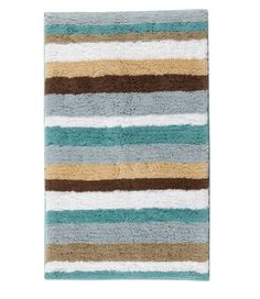 a bathroom rug with multicolored stripes on the bottom and tan, blue, brown, green, beige, and white colors