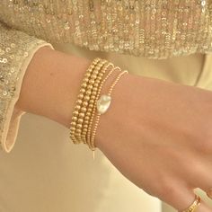 Elevate your wrist with our Gold-Filled Beaded Bracelet adorned with a lustrous freshwater pearl accent. This elegant piece combines the warmth of gold with the timeless beauty of pearls, creating a bracelet that effortlessly complements your style and adds a touch of sophistication to any ensemble. Handmade in the USADETAILS:-Material: 14K Gold-filled Natural Freshwater Pearl ( due they are natural pearls may vary the size and shape) Bead size 2mm What is 14k Gold-Fiiled ? Gold-filled jewelry i Elegant Everyday Pearl Stretch Bracelet, Delicate Gold Bracelets With Oyster Bracelet, Gold Pearl Bracelet With Oyster Detail, Adjustable Gold Pearl Drop Bracelet, Delicate Gold Oyster Bracelet, Gold Bracelet With Pearl Charm For Everyday, Gold Pearl Bracelet With Oyster Design, Elegant Adjustable Beaded Bracelet With Pearl Charm, Adjustable Yellow Gold Bracelet With Pearl Drop