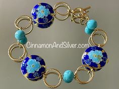 Blue Cloisonné and gemstone beaded bracelet adds a beautiful pop of summer boho color! Dark cobalt blue and bright turquoise colors are highlighted by metallic gold tones, with a fun circle and floral vintage boho motif! Bracelet is handmade from  twisted gold tone wire connecting rings, turquoise-dyed Howlite gemstone crystal beads, and cloisonné enamel coin beads.   Bracelet measures 8" long, but fits at 7.5" due to bead size. Can be lengthened by request. Closes with toggle clasp. Lead-free and nickel-free. Largest cloisonné bead is 1" diameter. Turquoise blue-dyed Howlite gemstone beads are 8mm. Cloisonné is an ancient enameling technique for decorating metalwork objects, with colored-glass paste placed within enclosures made of copper or bronze wires, which have been bent or hammered Blue Bangle Jewelry With Large Beads, Artisan Blue Beaded Bracelets With Round Beads, Bohemian Blue Bracelets With Spacer Beads, Blue Bohemian Bracelets With Spacer Beads, Artisan Blue Bangle Bracelet, Artisan Blue Bangle Bracelets, Artisan Blue Beaded Bracelet For Gift, Artisan Blue Beaded Bracelets As A Gift, Artisan Blue Beaded Bracelets For Gift