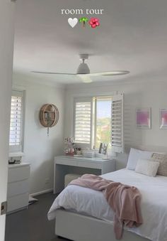 a bedroom with white furniture and pink accents on the walls, along with shuttered windows