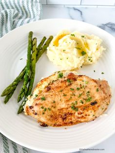 a white plate topped with chicken, mashed potatoes and asparagus