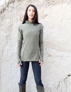 Style - The Turtleneck style is a classic, mildly relaxed turtleneck. Shape - The Simplicity follows the shape of the torso. Size - Order based on BUST measurement Fabric Shown - Stretch Organic Cotton Knit, Light Stretch Hemp/Organic Cotton Knit Color Shown - Olive Stretch Turtleneck Top For Everyday, Casual Funnel Neck Tops With Thumbholes, Green Funnel Neck Top For Layering, Stretch Funnel Neck Top For Everyday, Everyday Stretch Funnel Neck Tops, Casual Turtleneck With Thumbholes For Fall, Green Turtleneck Top For Layering, Casual Stretch Turtleneck With Thumbholes, Funnel Neck Top For Everyday