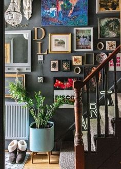 a staircase with pictures on the wall and plants in a planter next to it