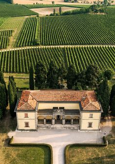 an aerial view of a large house in the middle of a field with many trees