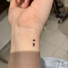 a person's wrist with a small tattoo on the left side of their arm