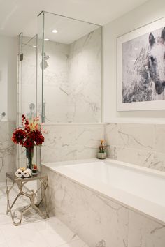 a white bathroom with marble walls and floor