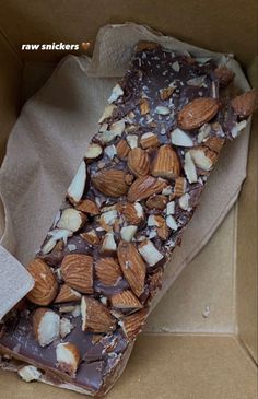 a box filled with chocolate and nuts on top of parchment paper next to a napkin