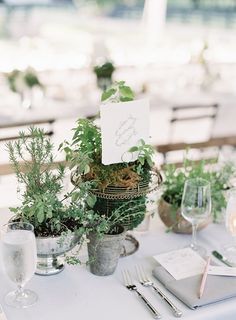 the table is set with silverware and greenery