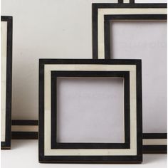 three black and white frames sitting next to each other