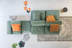 an overhead view of a living room with green couches and rugs on the floor