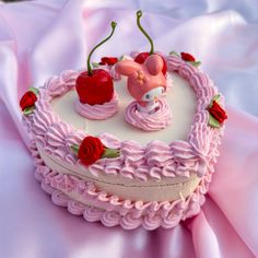 a heart shaped cake with pink frosting and decorations