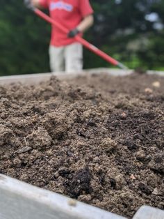 a man is shoveling dirt into a container