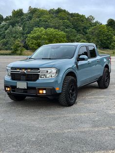 a blue pick up truck parked in a parking lot