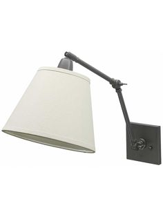 a wall light with a white shade on it's arm and the lamp plugged in