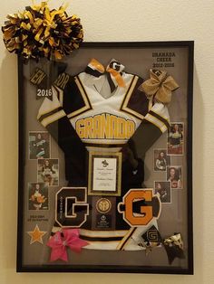 an award plaque is displayed in front of a cheerleader's uniform and pom - poms