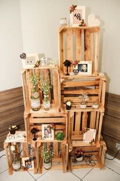 several wooden crates stacked on top of each other with pictures and plants in them sitting on the floor