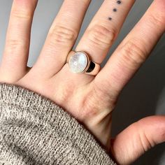 "Pictured here is a vibrant moonstone ring that weighs 8.2 grams and is US size 7 1/4. It is framed in sterling silver. This ancient gem, moonstone, has been admired for centuries. It was thought that moonstone was created from rays of the moon which provided a feeling of mystery and magic for those who held it. Moonstone is thought of as the \"'lovers' stone\" which evokes tender feelings and safeguarding the true joys of love. Some believe that wearing this stone strengthens our intuition and Silver Moonstone Ring For Healing With Moon Phase, Everyday Oval Moonstone Ring, Sterling Silver Round Moonstone Ring With Moon Phase, White Moonstone Ring With Si Clarity, White Sterling Silver Moonstone Ring In Celestial Style, Everyday Round Moonstone Ring, Sterling Silver Oval Rings With Moon Phase, Sterling Silver Oval Rings With Moon Phase Detail, White Moonstone Ring With Polished Sterling Silver