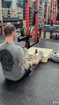 a man sitting on the ground in a gym