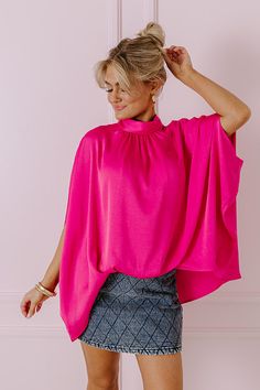 - Get in a chic state of mind with this trendy top! - Unlined lightweight material with a satin finish - A mock neckline with back tie closure and a keyhole detail - Draped half sleeves - An oversized silhouette that ends in an uneven hemline with a gathered elastic detail in front High Neck Spring Blouse, Chic Stretch Mock Neck Top For Party, Pink High Neck Top For Summer, Chic Pink Half-sleeve Blouse, Chic Pink Half Sleeve Blouse, High Neck Pink Top For Summer, High Neck Summer Blouse For Party, High Neck Summer Party Blouse, Chic Pink Stretch Blouse