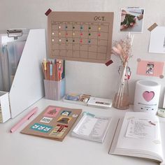 a desk with a calendar, pens and other items on it