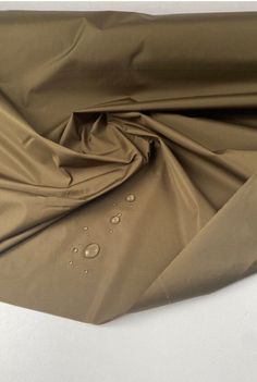 Khaki Tone- Waterproof Twill Fabric. Haute Couture French Designer Brand.  This weighty fabric has a luxurious feel and drape. It is a non-stretch type and fully waterproof, ideal for raincoats and trench coats. It comes directly from the design house of a very famous luxury French designer brand.  Composition: Polyamide Density- 140.00 g/m² Width- 145.00 cm Purpose- Raincoat, Trench Coat Weaving- Twill Stretch- Non-stretch Color- Shade of green All fabrics are portrayed in a natural light. If you require additional images and videos, please message us. Trench Coat Fabric, Waterproof Khaki Nylon Raincoat, Khaki Nylon Waterproof Raincoat, Khaki Waterproof Nylon Raincoat, Fabric Texture Material Fashion Textiles, Solid Waterproof Raincoat, Waterproof Khaki Raincoat For Rainy Weather, Types Of Clothes Fabrics, Raincoat Trench