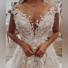 a woman wearing a wedding dress with flowers on it