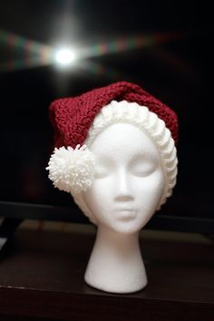 "Crochet Santa hat in ivory and cranberry. Created using the Red Heart pattern.  Size large (adult)  Hat circumference approx 20\" stretches to 23\".  Made using 100% Acrylic yarn (Hobby Lobby I Love this Yarn)  Machine wash cold, lay flat to dry.  If you have any questions feel free to ask. Matching Christmas Stocking coming soon." Red Hat As A Gift, One Size Fits All, Red Hat As A Gift, Winter White Crochet Hat As Gift, White Crochet Hat For Winter Gift, White Hat One Size Gift, White Christmas Holiday Hat, White Crochet Beanie Hat As Gift, White Christmas Hat As Gift, White Christmas Cap