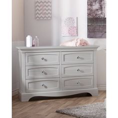 a white dresser with lots of drawers in a room