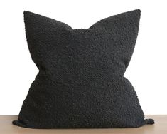 a black pillow sitting on top of a wooden table